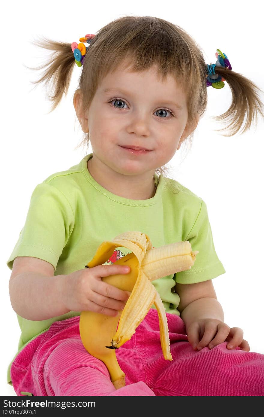 Little girl eats a banana. Studio shot