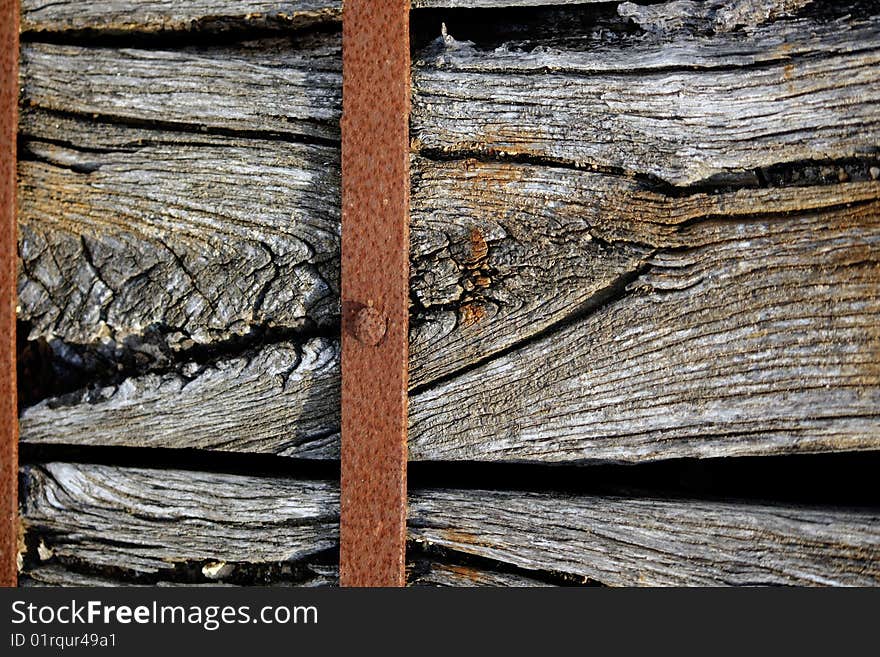 Closeup view of a old piece of wood wrapped with a rusty metal. Closeup view of a old piece of wood wrapped with a rusty metal.