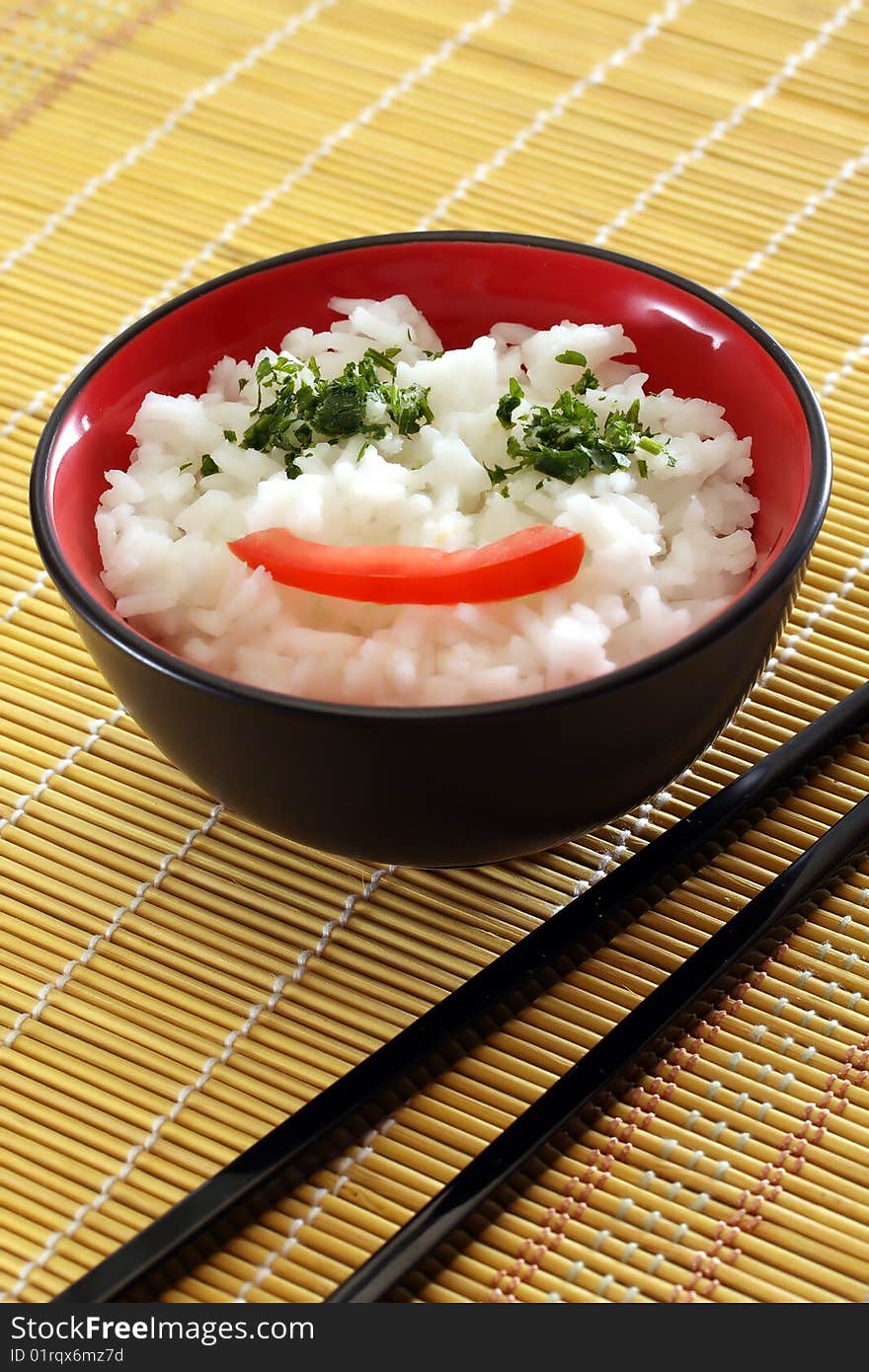 Chinese food in a black plate and sticks