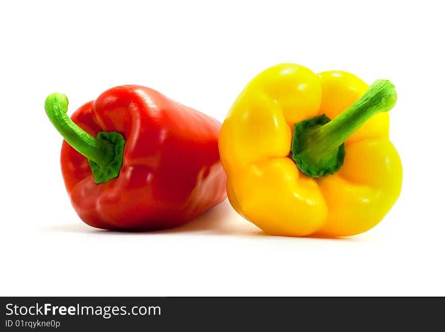 Yellow and red shiny ripe appetizing peppers on a white background. Yellow and red shiny ripe appetizing peppers on a white background