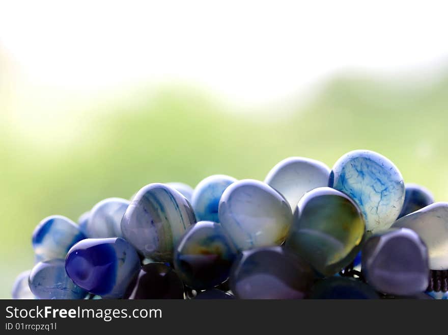 a close up picture of smooth polished blue veined stones with green background.