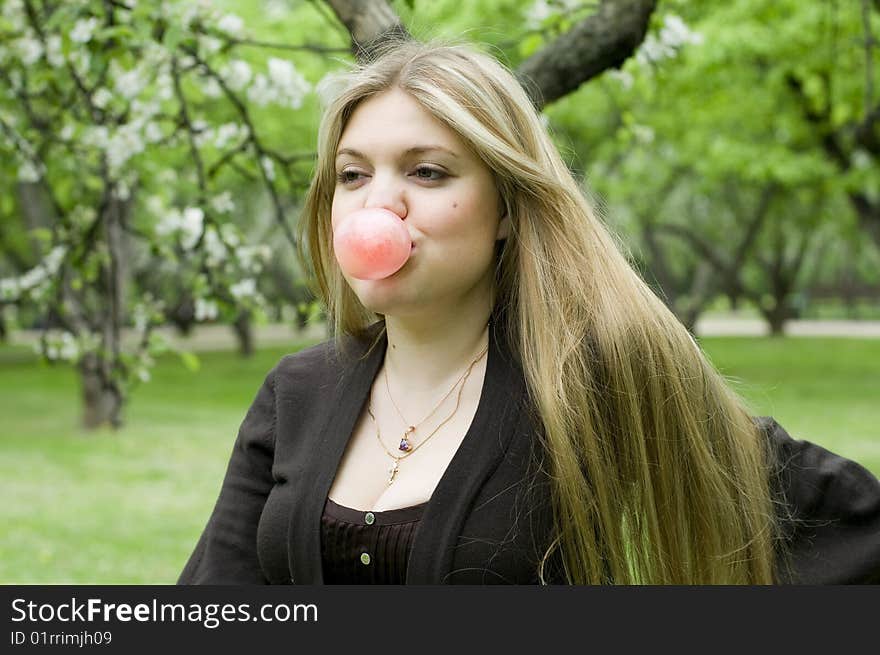 Playful blond girl blowing bubble with bubble gum