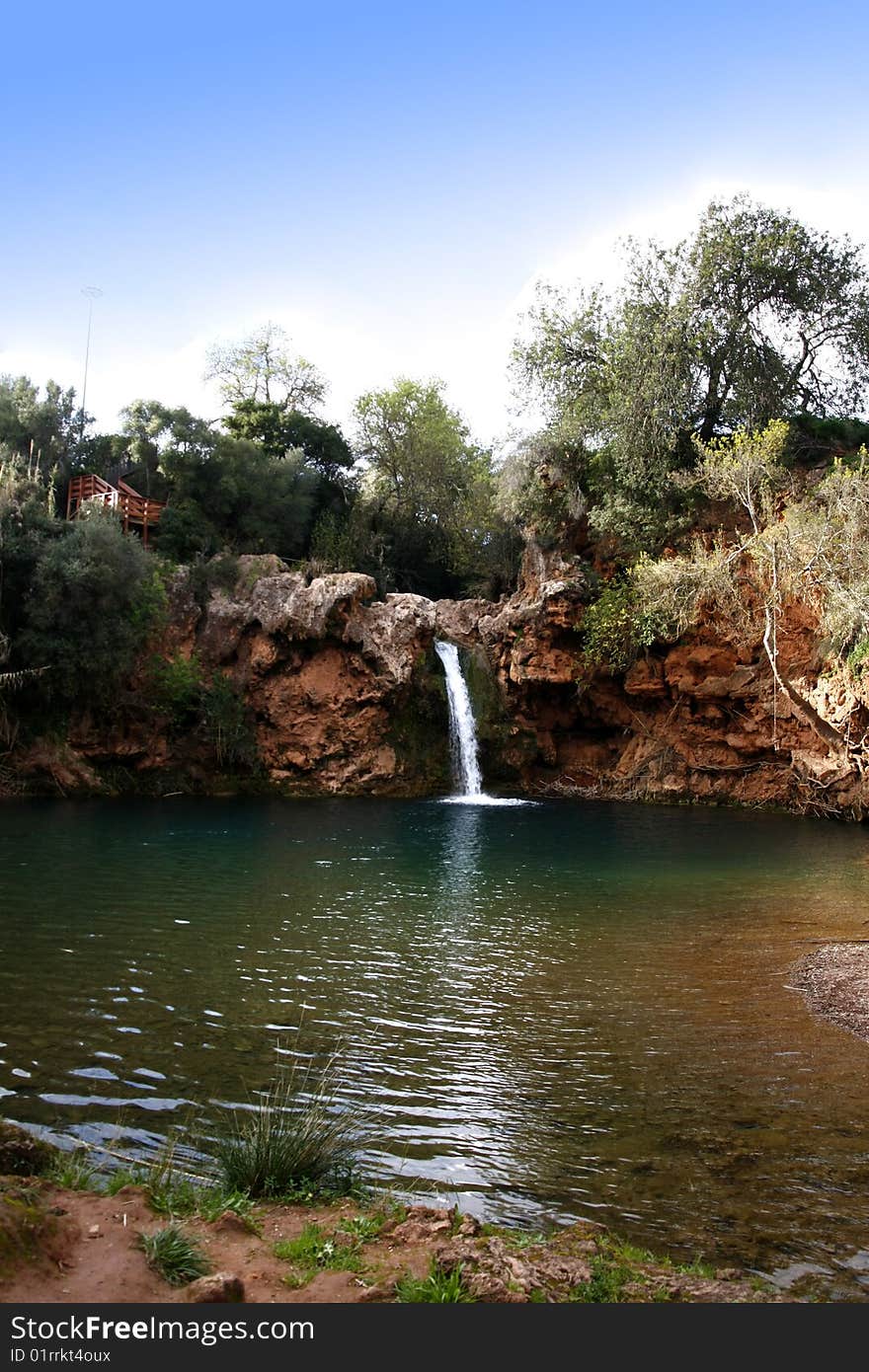 Beautiful waterfall with lake and wooden access located near Tavira, Portugal. Beautiful waterfall with lake and wooden access located near Tavira, Portugal.