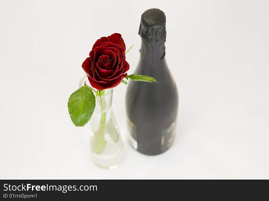 A beautiful red rose and a bottle of champagne. A beautiful red rose and a bottle of champagne