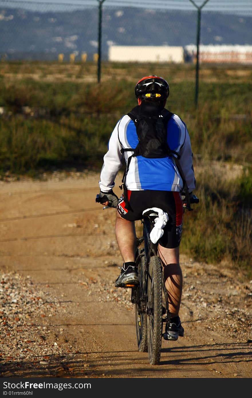 Man wearing sport cloths, riding a bike on the countryside. Man wearing sport cloths, riding a bike on the countryside.