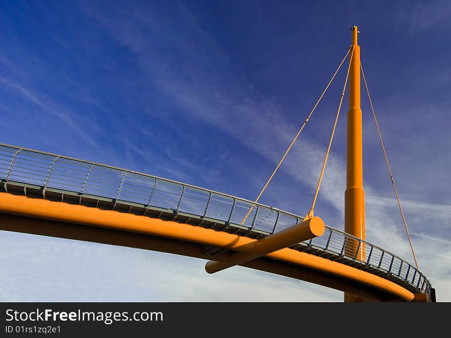 A orange rope bridge in blue sky