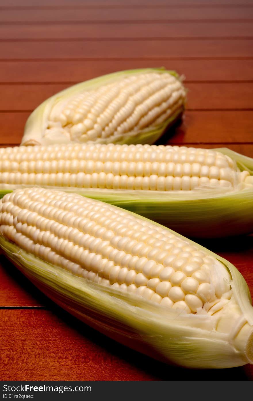 Vertical shallow focus close up of three cobs on corn