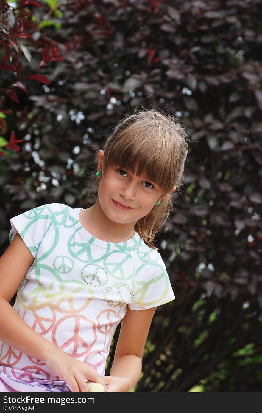 A portrait of a cute young girl with sidewalk chalk. A portrait of a cute young girl with sidewalk chalk