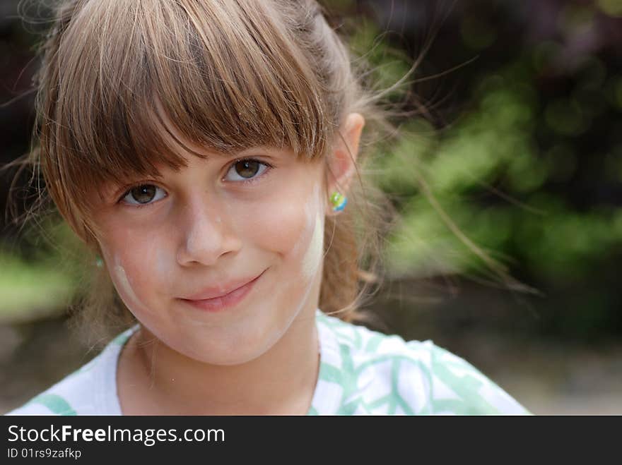 A portrait of a cute young girl with chalk on her face. A portrait of a cute young girl with chalk on her face