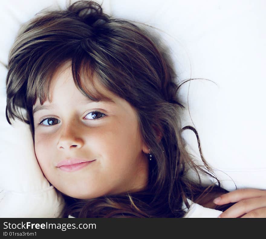 A cute young girl relaxing in a bed. A cute young girl relaxing in a bed