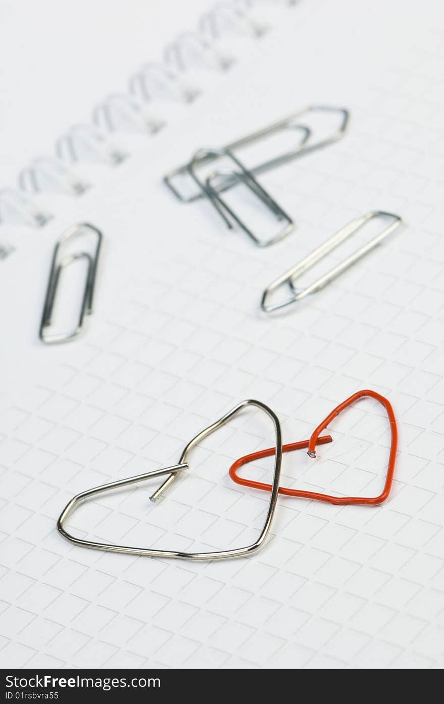 Two paper-clips, formed to as a heart. Two paper-clips, formed to as a heart