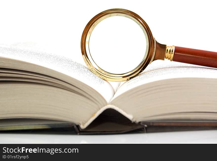 Magnifier and the book. A white background. Close-up.