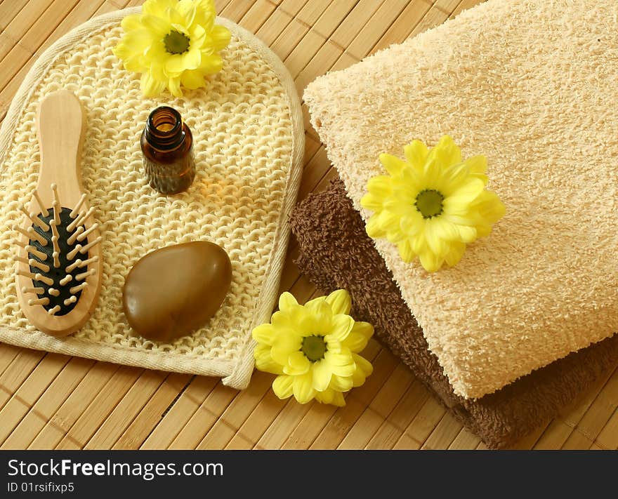 towel, bottle, stone and flowers