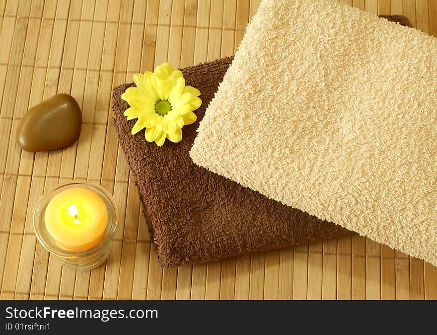 Spa background. towels, stone, yellow flower and candle. Spa background. towels, stone, yellow flower and candle