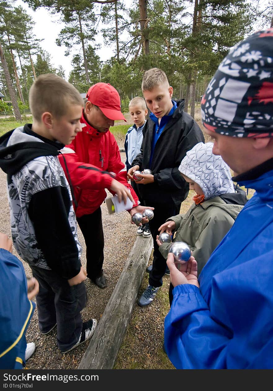 Group of men and boys playing boulle together. Teams are getting ready to play. Group of men and boys playing boulle together. Teams are getting ready to play.