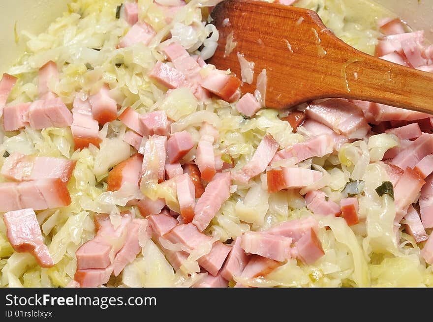 Cooking cabbage with ham in a pan