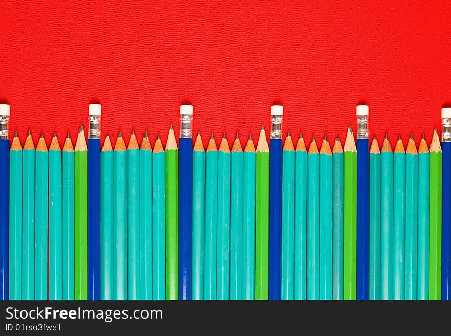 A lot of pencils on red backgrounds, focus on middle group of pencils