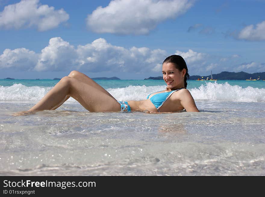 A girl lying down on her back in shallow water. A girl lying down on her back in shallow water.