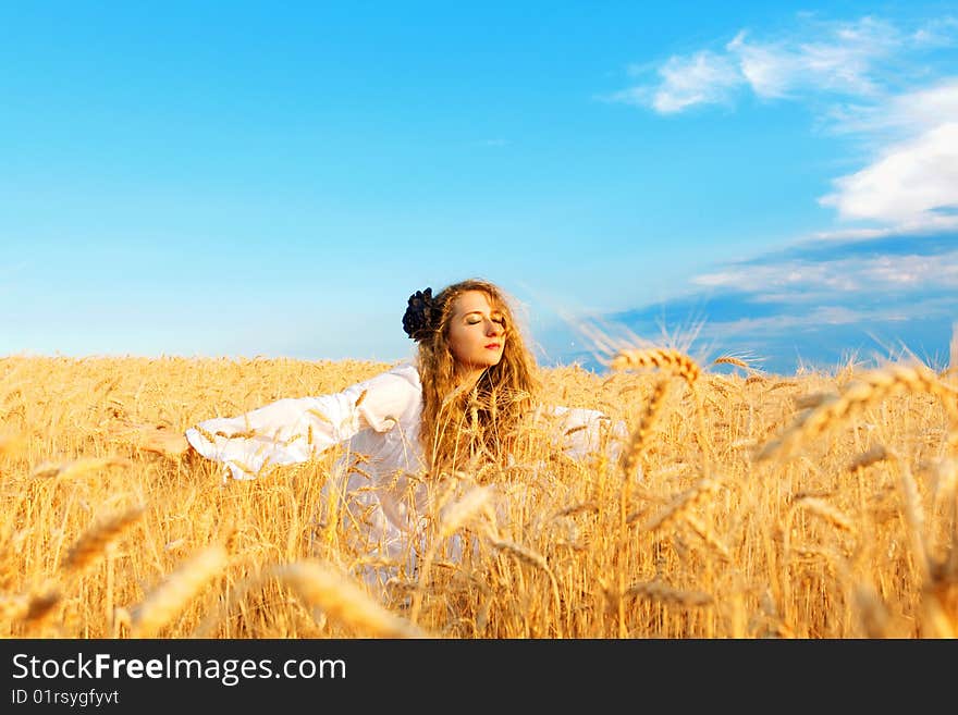 Woman relaxing in wheat field at sunset. Woman relaxing in wheat field at sunset