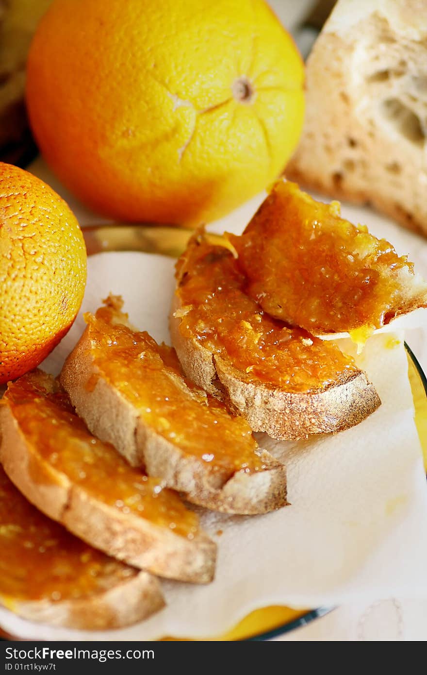 View of some slices of bread with orange jam on them.