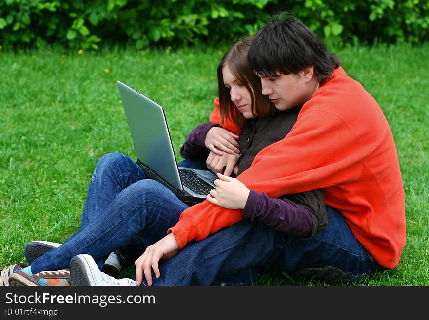 couple on grass with laptop computer