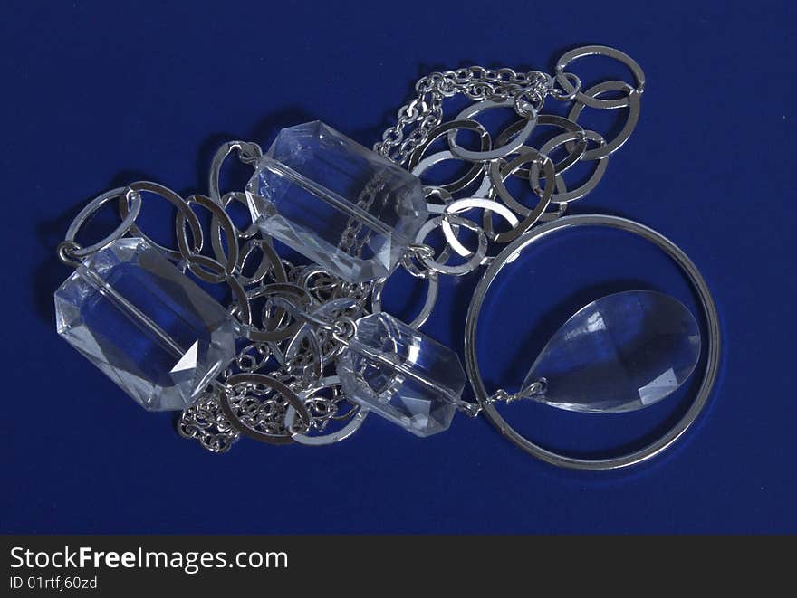 Costume jewellery of silvery color on dark blue background