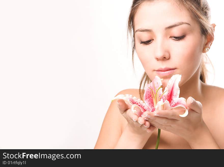 Beautiful young woman contemplating a flower