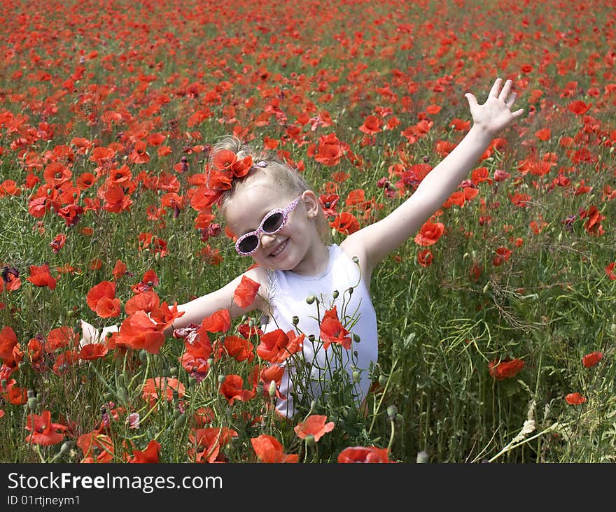 On the image there is a little girl. She is in  field of  wild flowers.