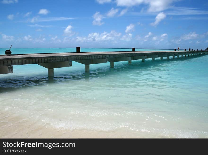 Wooden jetty on over the beautiful Maldivian beach