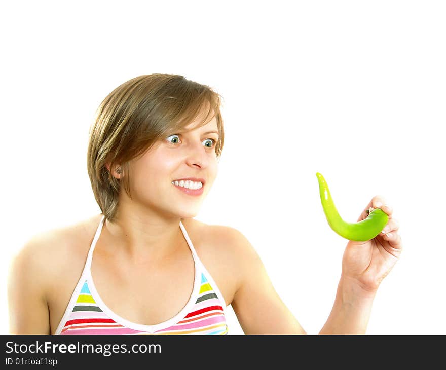 Portrait of a young cute Caucasian blond lady with a nice colorful striped summer dress who is going crazy and she is holding a fresh green chilly pepper in her hand. Isolated on white. Portrait of a young cute Caucasian blond lady with a nice colorful striped summer dress who is going crazy and she is holding a fresh green chilly pepper in her hand. Isolated on white.