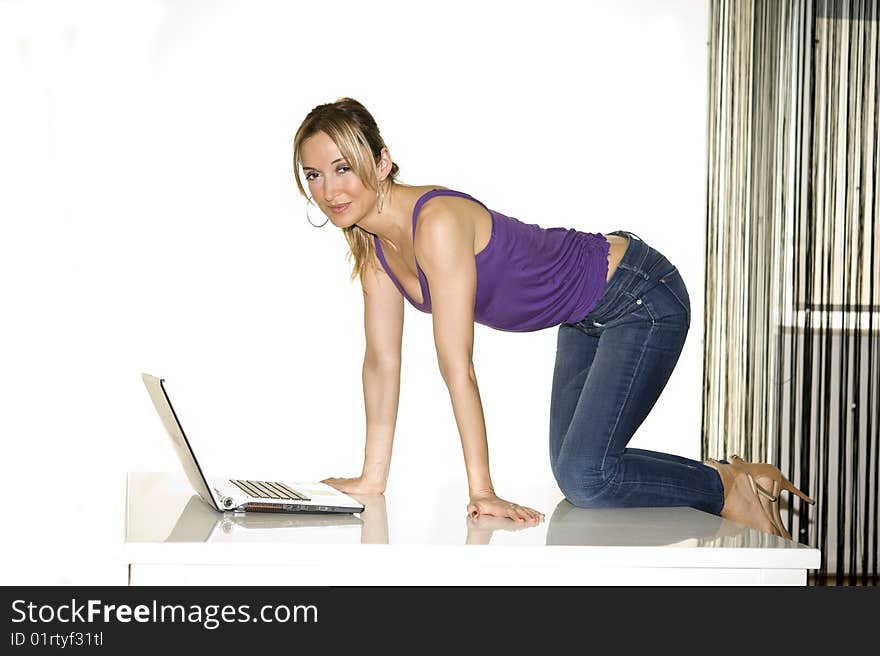 Young attractive woman in tshir blue jeans on professional laptop computer, on white backdrop. Young attractive woman in tshir blue jeans on professional laptop computer, on white backdrop