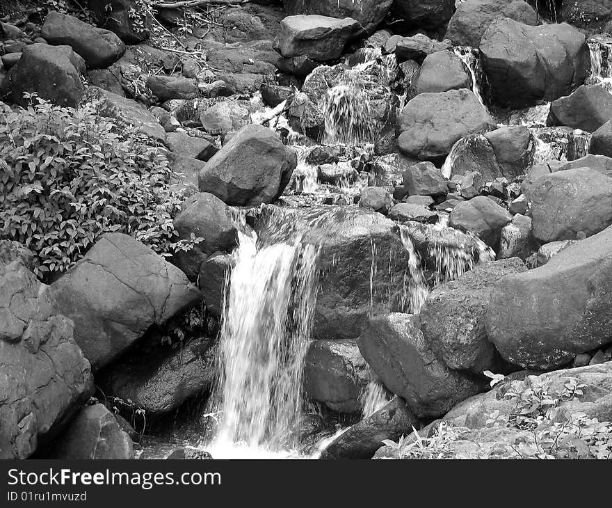 A natural scene of a flowing water and rocks. A natural scene of a flowing water and rocks.