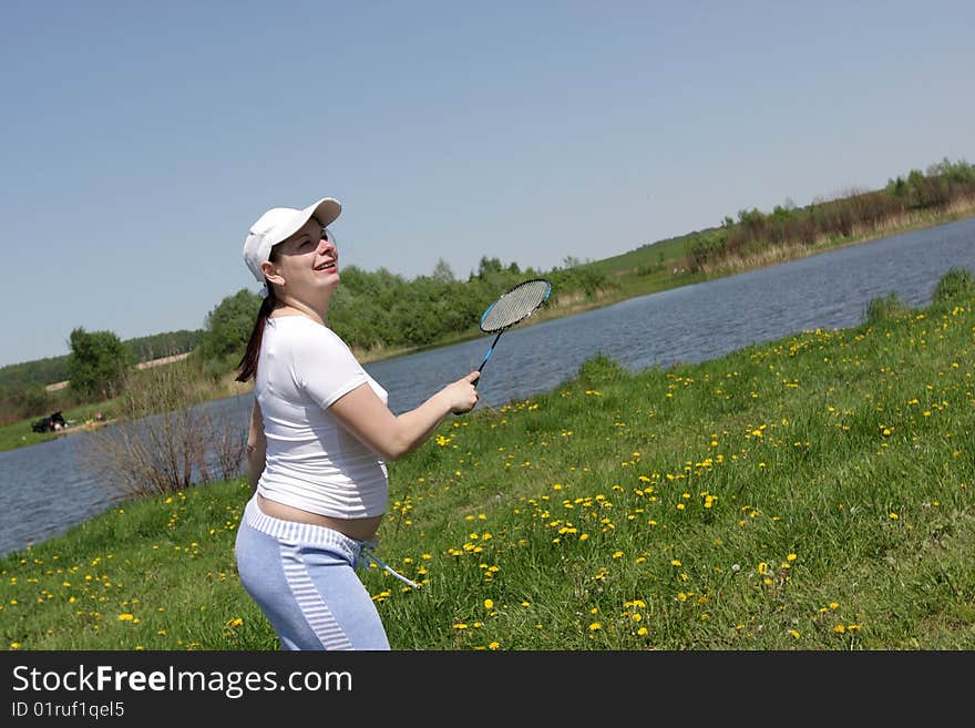 The active pregnant woman plays in badminton