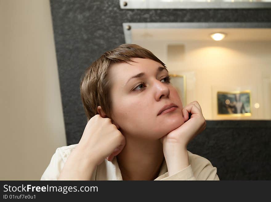 The dreamy woman waits a waiter in cafe