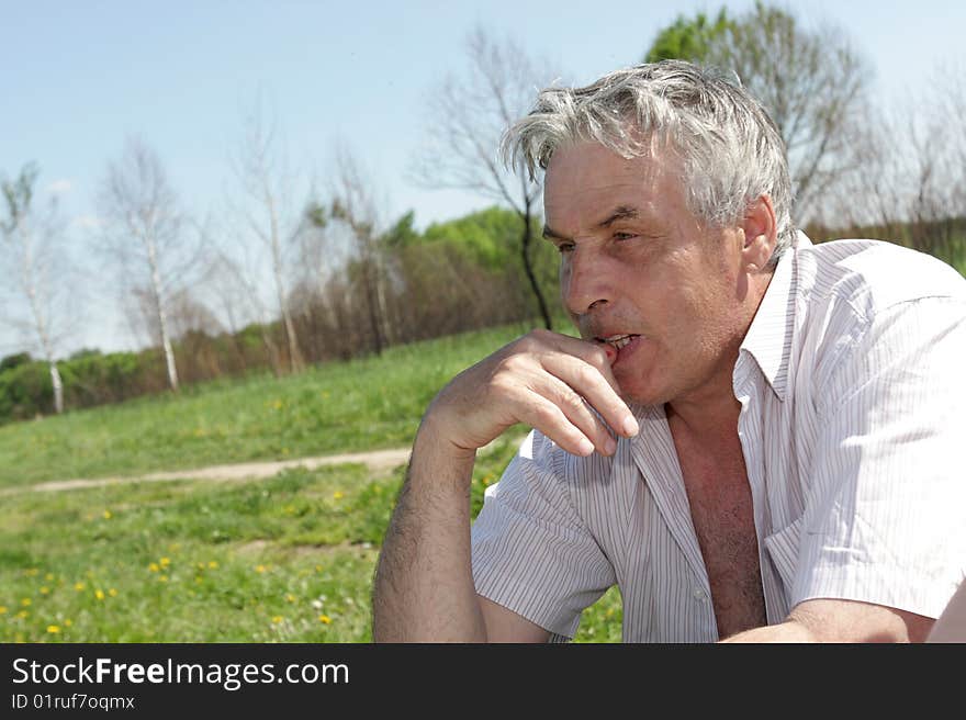 Pensive mature man resting outdoor in summer. Pensive mature man resting outdoor in summer