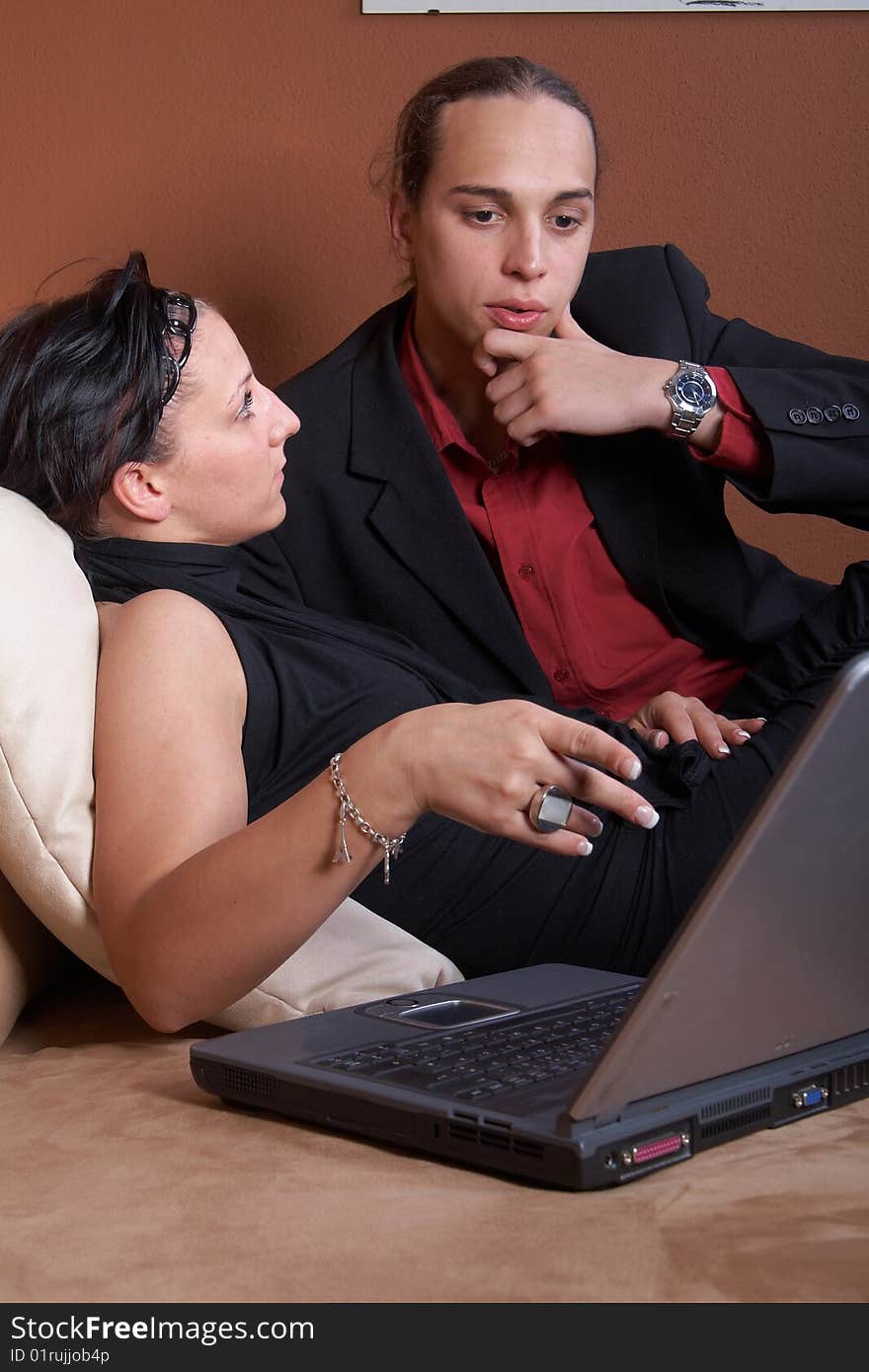 Young couple on the couch surfing the web with their laptop. Young couple on the couch surfing the web with their laptop.