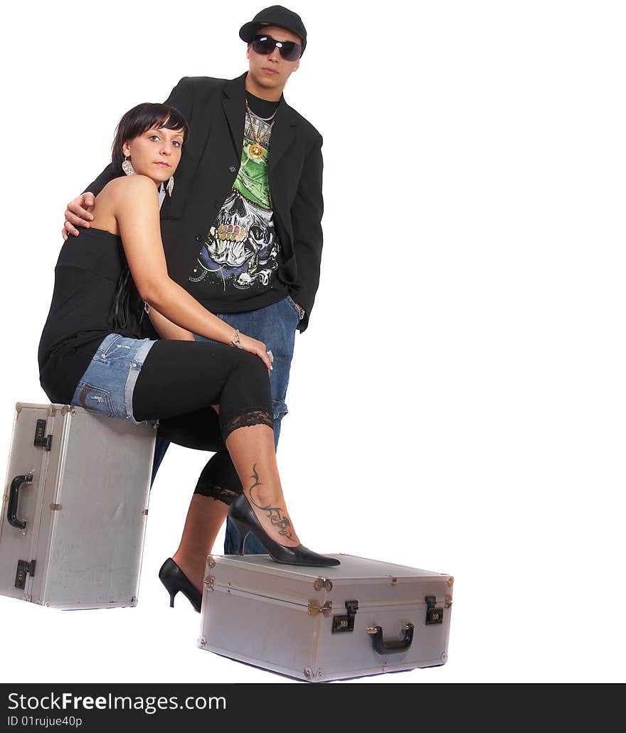 Young stylish couple isolated over white. She is sitting on dj cases. Young stylish couple isolated over white. She is sitting on dj cases.