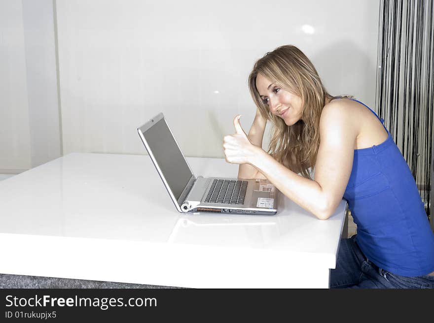 Young attractive woman in tshir blue jeans on professional laptop computer, on white backdrop. Young attractive woman in tshir blue jeans on professional laptop computer, on white backdrop