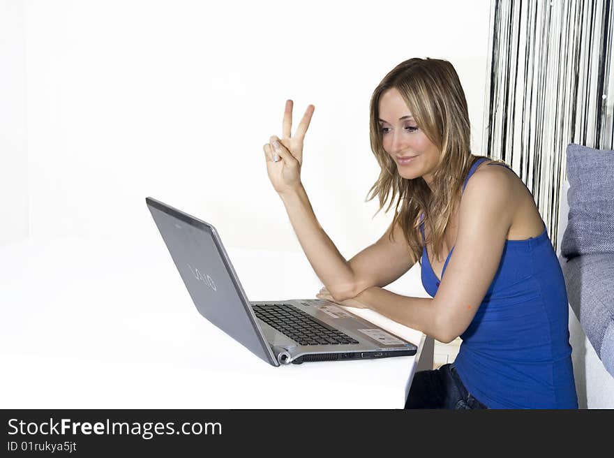 Young attractive woman in tshir blue jeans on professional laptop computer, on white backdrop. Young attractive woman in tshir blue jeans on professional laptop computer, on white backdrop