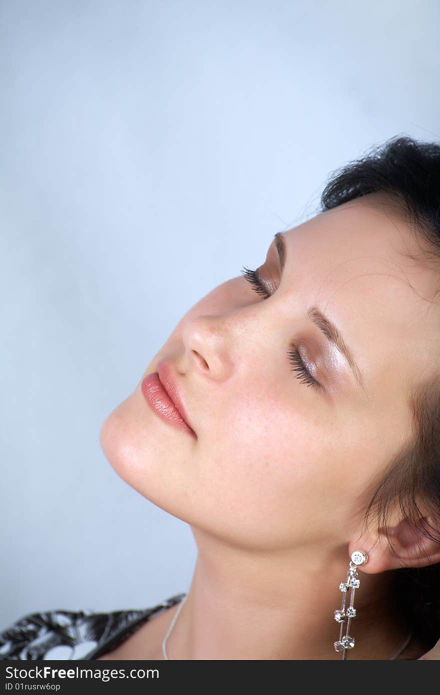 Woman with closed eyes on light blue background. Woman with closed eyes on light blue background