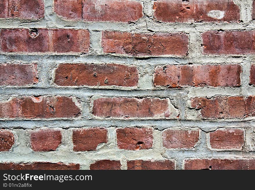 A fragment of a brick wall with cracked cement in between the old bricks. A fragment of a brick wall with cracked cement in between the old bricks.