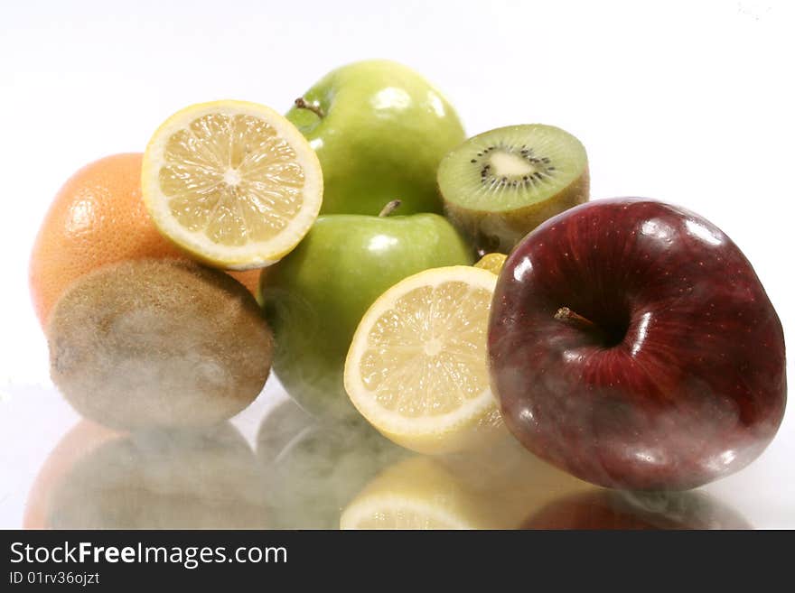 Assorted fruits with their reflection and smoke