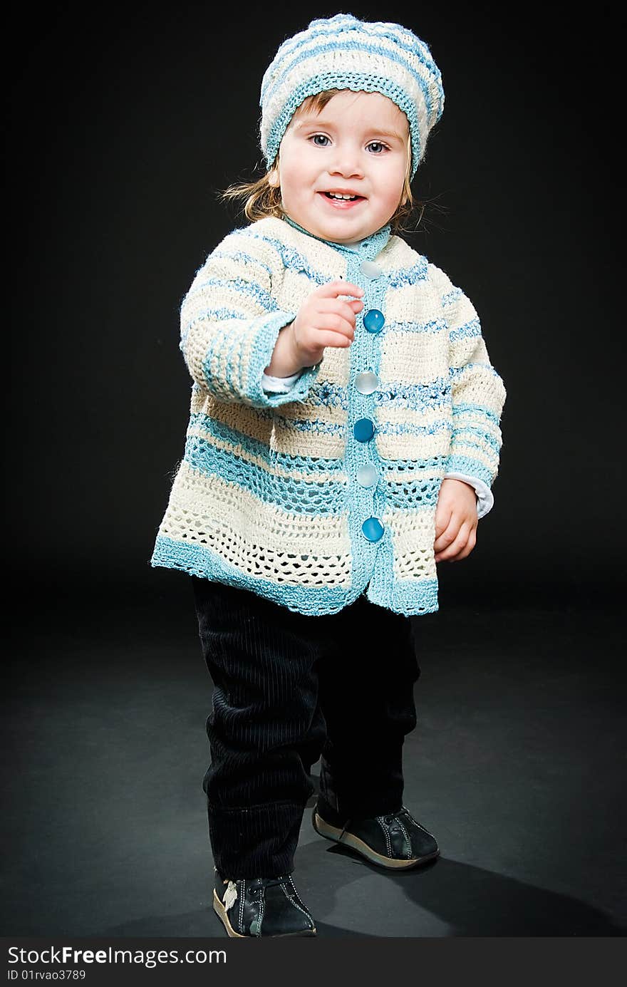 Portrait of smiling baby in full height on black