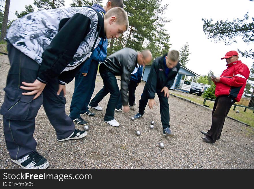 Group of men and boys playing boulle together. Checking the score. Motion blurred applied. Group of men and boys playing boulle together. Checking the score. Motion blurred applied.