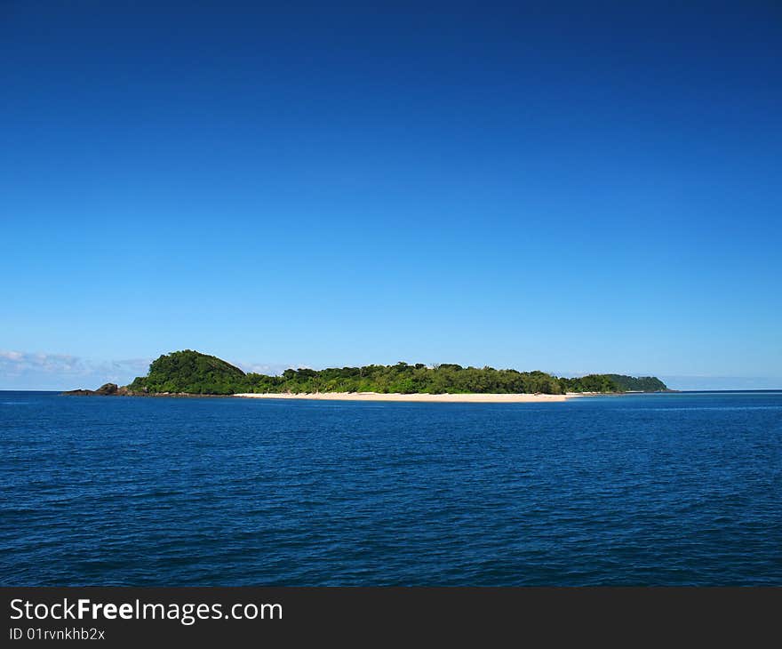 A tropical island paradise against a clear blue sky