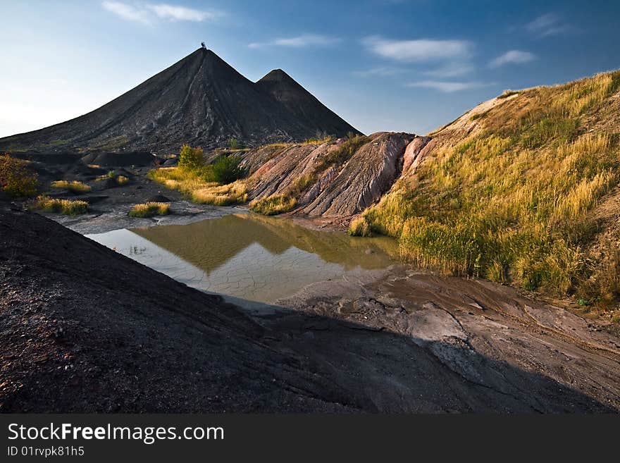 Reflection of yhe hills of old colliery in small lake in Ukraine. Reflection of yhe hills of old colliery in small lake in Ukraine