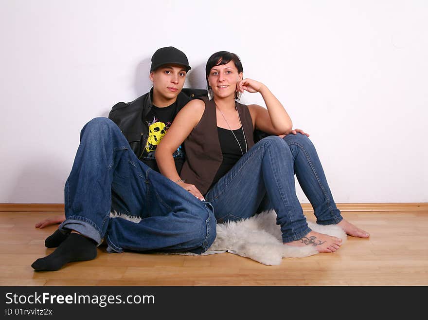 Young stylish couple sitting on the floor of their new home!. Young stylish couple sitting on the floor of their new home!