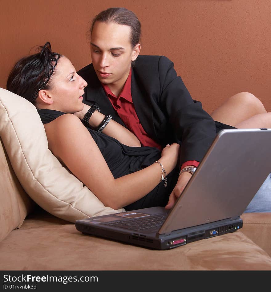 Young couple on the couch surfing the web with their laptop. Young couple on the couch surfing the web with their laptop.