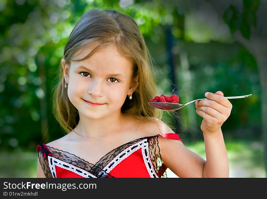 Girl eating raspberry