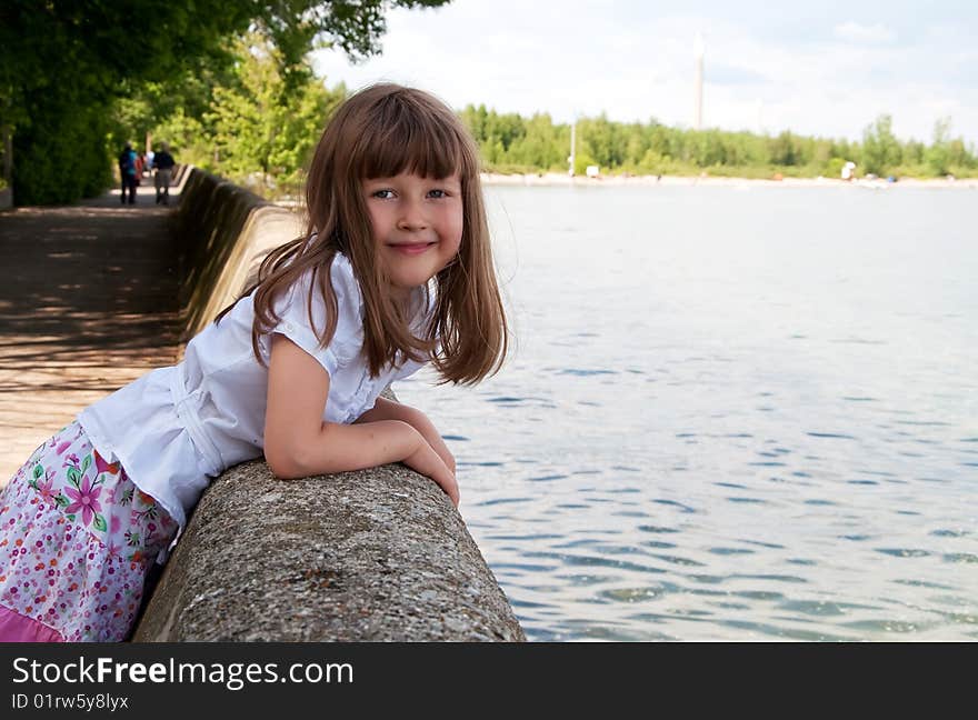 Smiling cute little girl on the lake